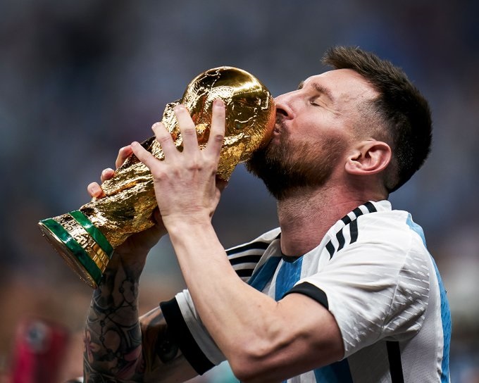 Lionel Messi mencium trofi juara usai bungkam Prancis di laga final Piala Dunia 2022. Sumber: Twitter @brfootball