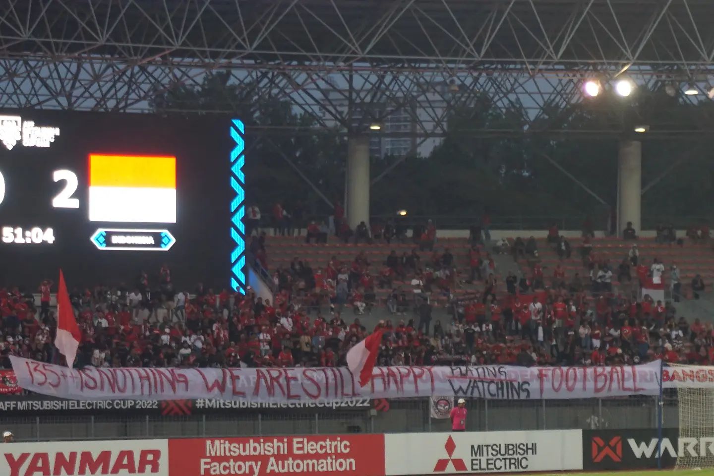 Supporter Indonesia membentangkan banner berisi protes atas tragedi kanjuruhan. Sumber foto : Twitter @panditfootball