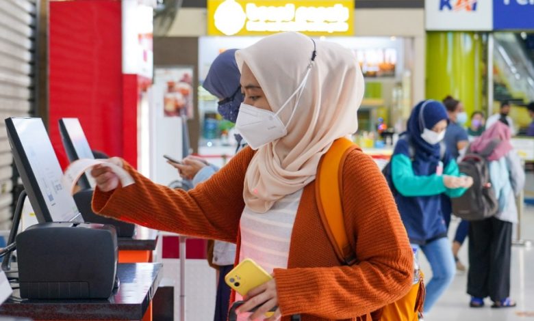 Seorang pemudik perempuan sedang boarding pas mudik gratis. Sumber foto: PT KAI