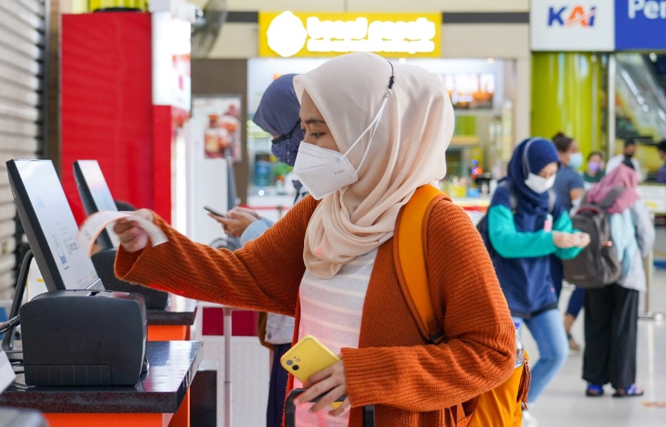 Seorang pemudik perempuan sedang boarding pas mudik gratis. Sumber foto: PT KAI