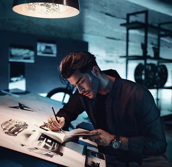 Man sitting in front of laptop at the table with lamp and writing documents. Sumber Foto: Pinterest